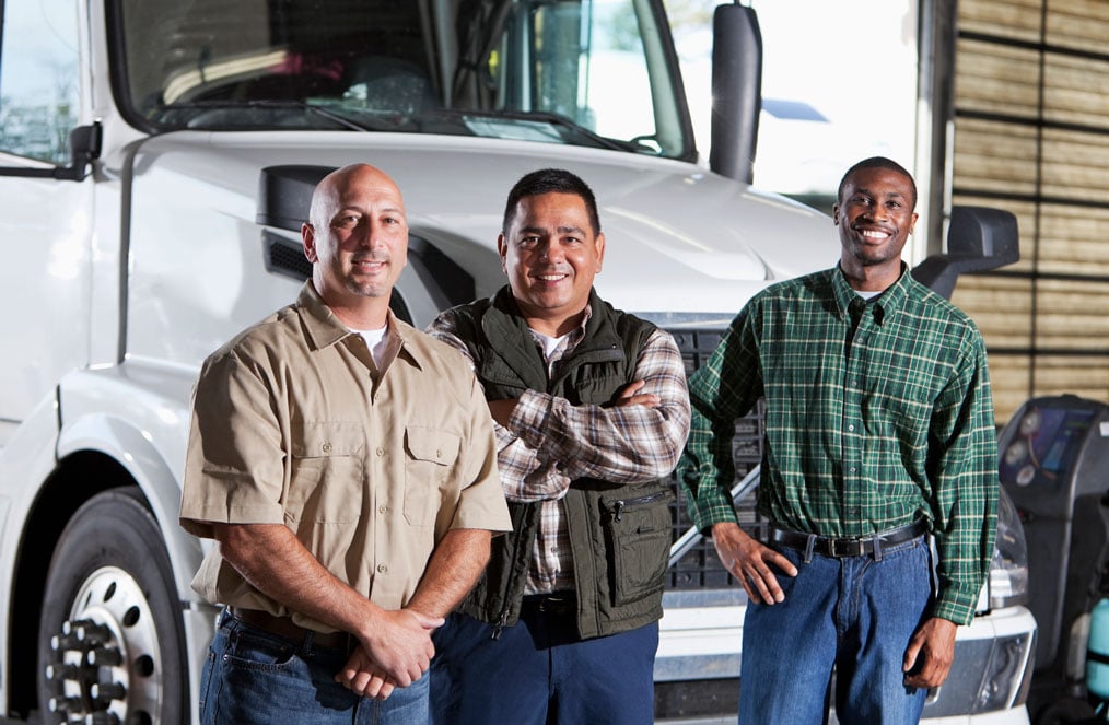 Three men standing in front of a white semitruck